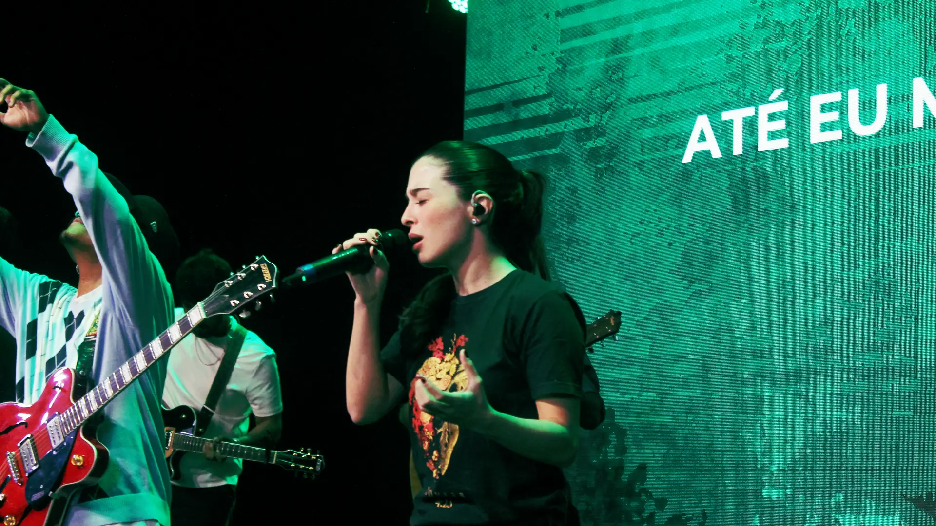 Uma cantora e um guitarrista do Louvor no palco